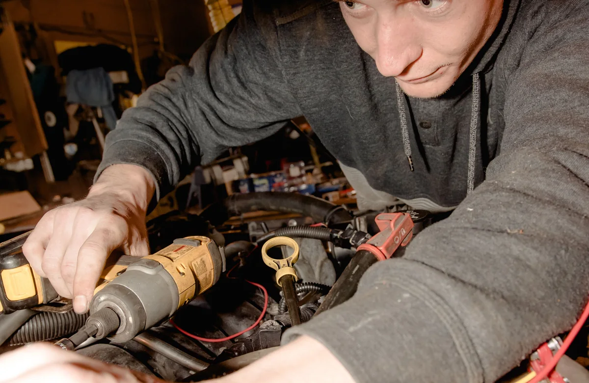Mechanic working beneath an open bonnet, used as the preview for the Garage and MOT website template